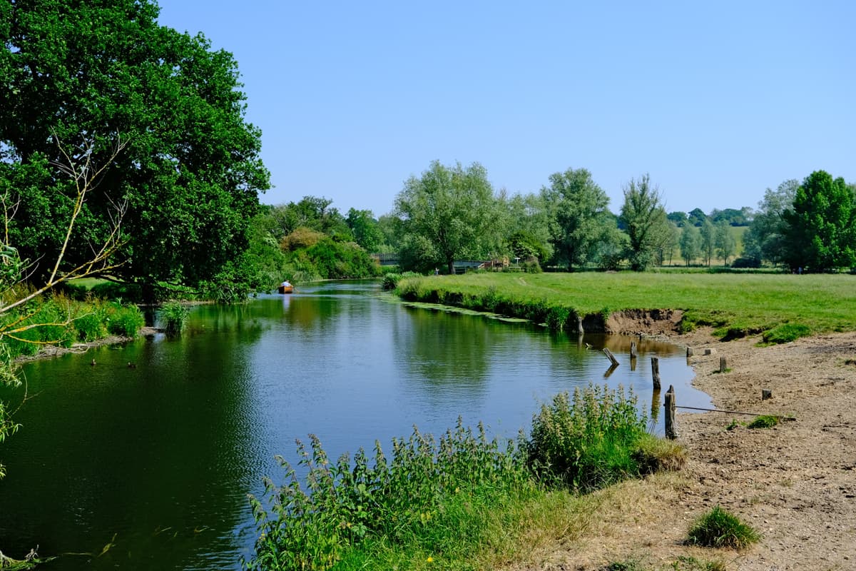 Landscape image of Dedham Vale. It's a clear and sunny day, and the river is running through the countryside.