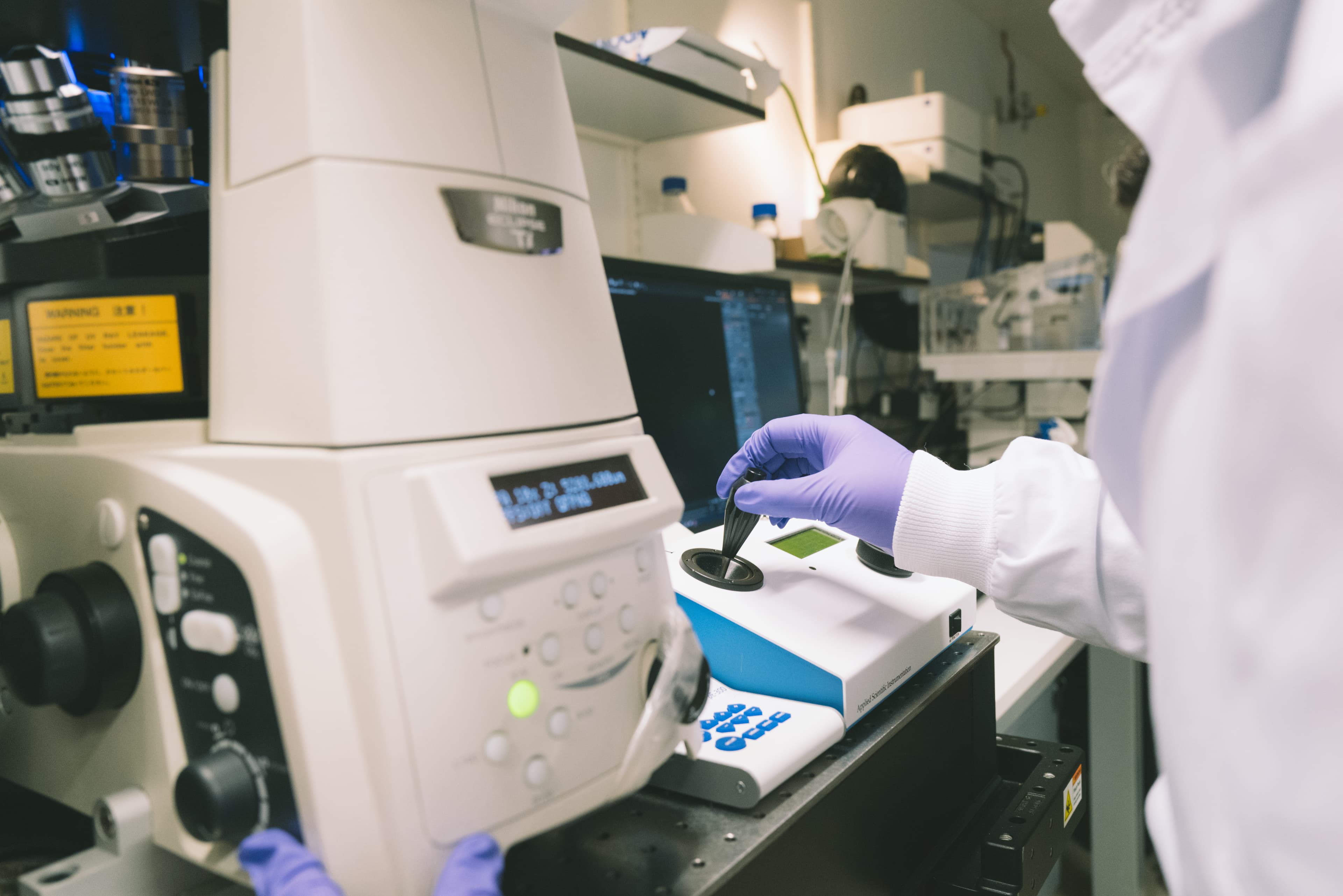 Hand shot of researcher working on a lab equipment. Cambridge lab with our researchers working alone.