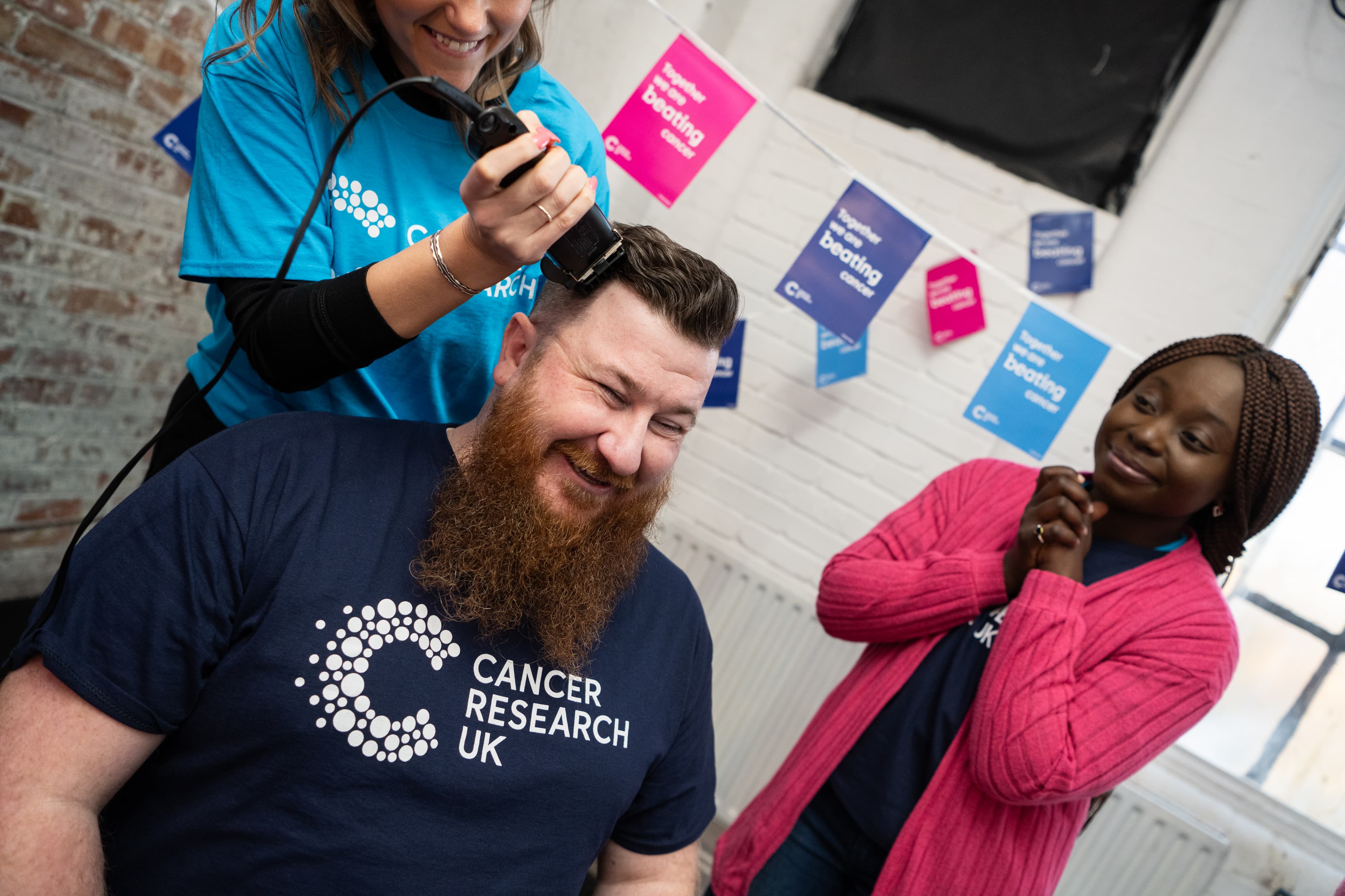 A photo of a Cancer Research UK volunteer shaving his head.