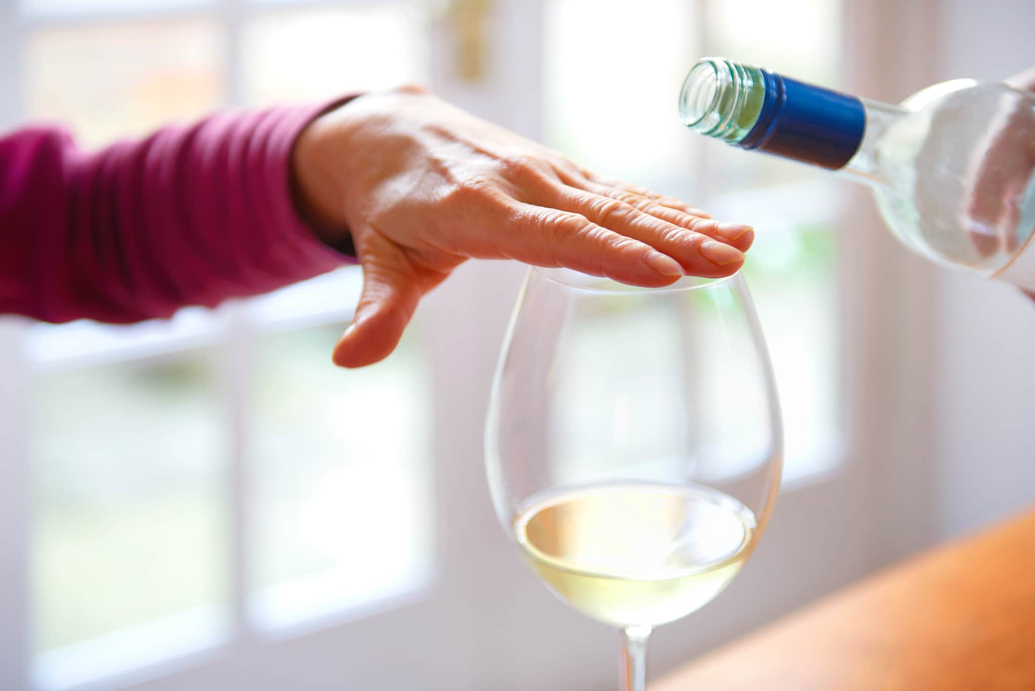 Hand covering glass to signal not to refill.