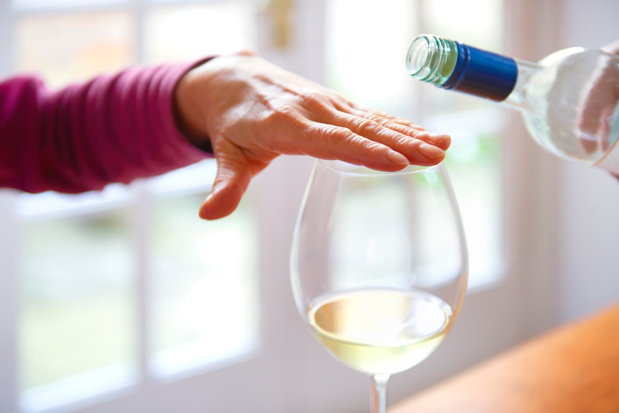 Hand covering glass to signal not to refill.