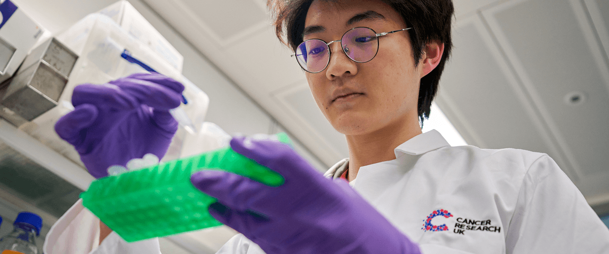 Researcher holding a tray of test tubes.