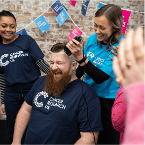 A photo of a Cancer Research UK volunteer getting a head shave.