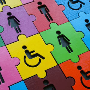 Puzzle pieces with graphics of men, women, and wheelchair users on them.