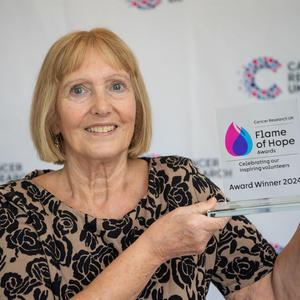 Mal holding her Flame of Hope trophy