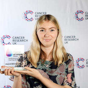 Shannon holding her Flame of Hope trophy