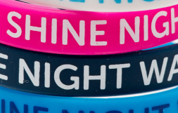 Image of pink and blue wristbands with Shine Night Walk written on them